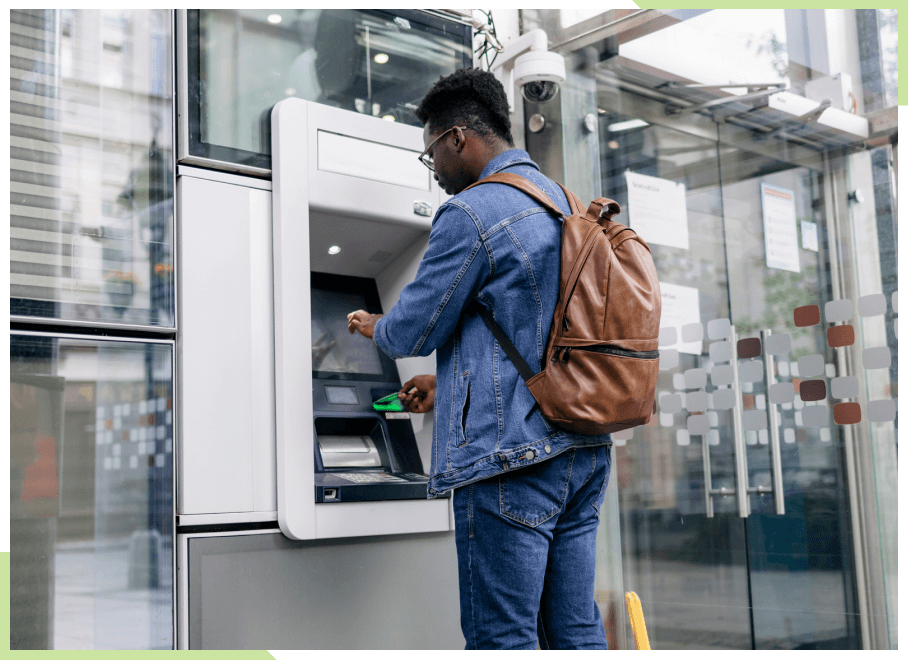 Young man using an ATM machine outside