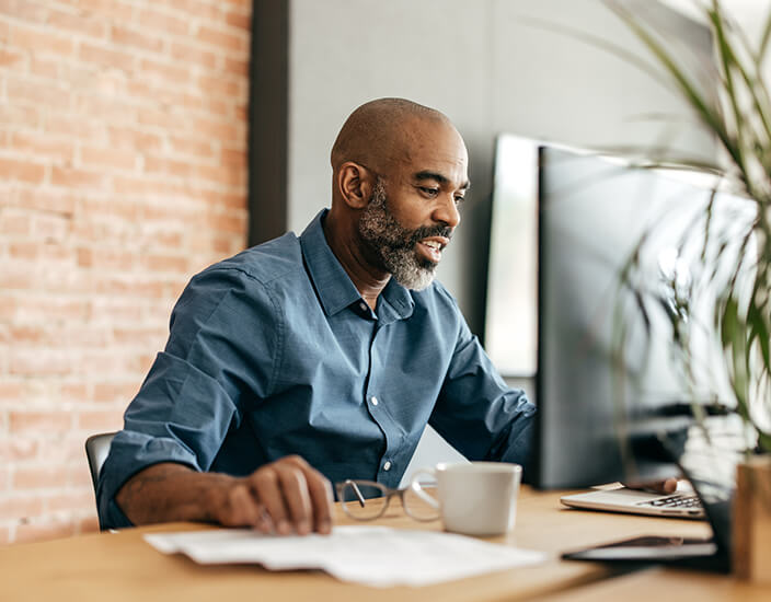 Older man using a desktop computer monitor