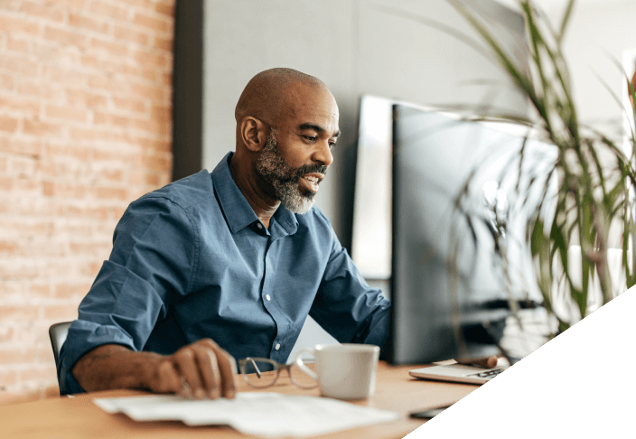 Man working at a table with a desktop computer