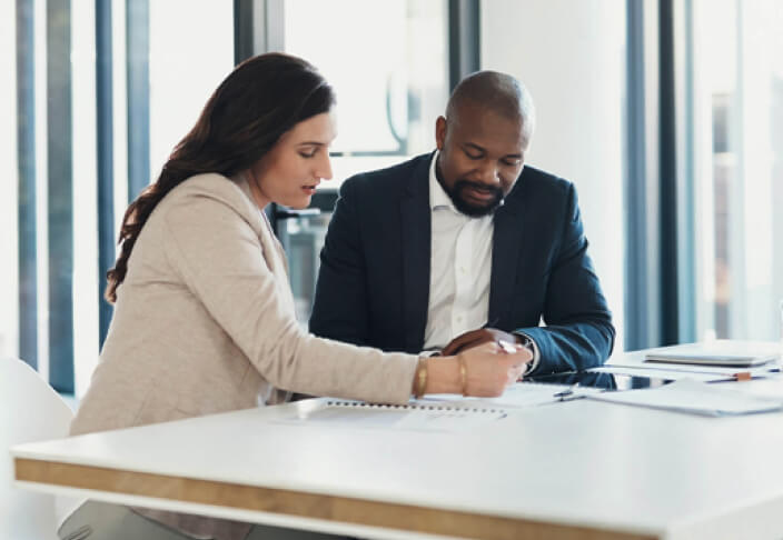 Man and woman working at a table in a polished office setting